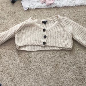 A pale sweater with three buttons